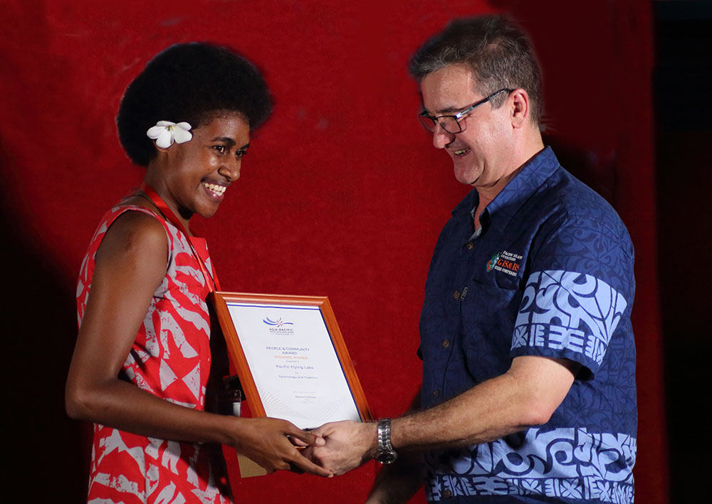 Ms. Kolora Qativi representing Pacific Flying Labs receiving the award from Mr. Kinne